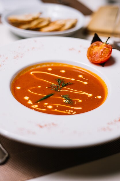 Tomatensuppe von der Seite mit Käse und Sahne mit einer Tomatenscheibe