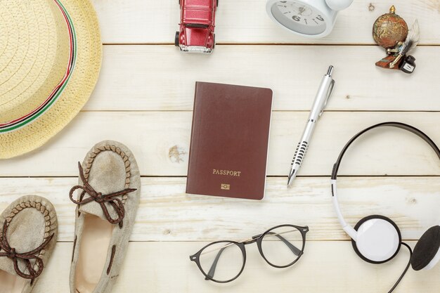Top-Ansicht wesentliche reise items.The Schuhe Notebook Baum Karte Pass Flugzeug Auto Brillen auf rustikalen hölzernen Hintergrund.