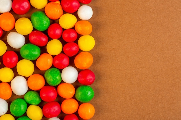 Kostenloses Foto top bunte bonbons mit kopienplatz auf ocker