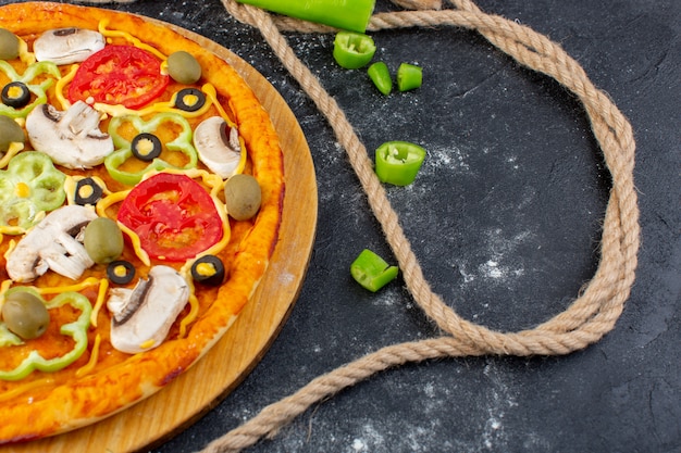 Top Close View leckere Pilzpizza mit roten Tomaten Oliven Pilze mit frischen Tomaten überall auf dem grauen Schreibtisch Pizzateig backen Fleisch Essen