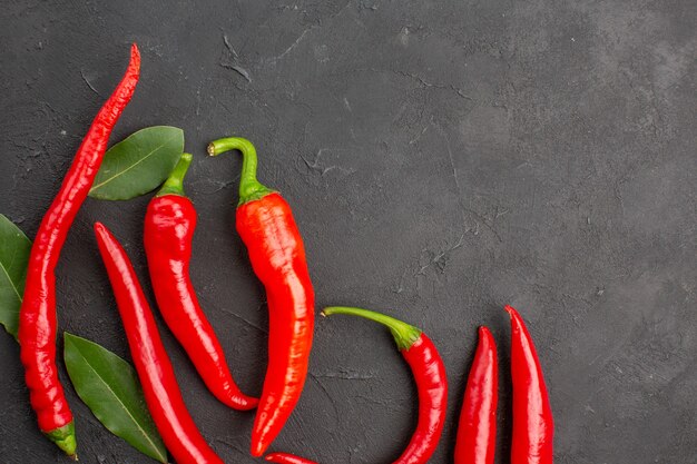 Top Close View rote Paprika und Pay Leaves auf schwarzem Tisch mit Kopierraum