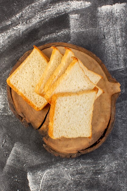 Top-Fernsicht-Brotlaibweißbrot auf dem braunen hölzernen Schreibtisch und dem grauen Hintergrundteigbrotbrötchen