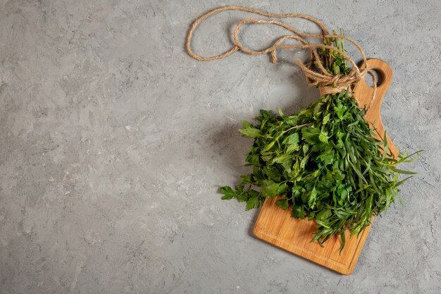 Top frische Kräuter auf Holz Schneidebrett auf grau