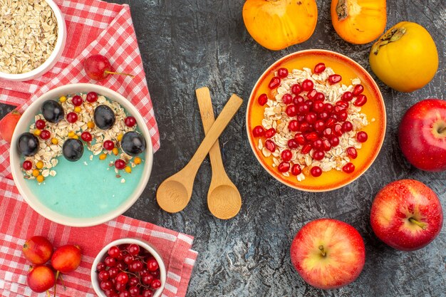 Top Nahaufnahme Ansicht Beeren Löffel Schalen von Kaki-Beeren Haferflocken auf der Tischdecke