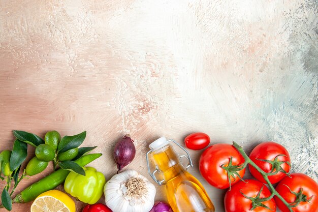 Kostenloses Foto top nahaufnahme ansicht gemüse knoblauch paprika zitronenöl zwiebel tomaten mit stielen