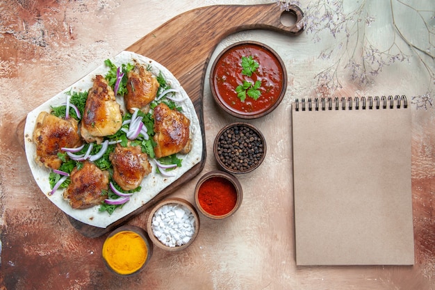 Top Nahaufnahme Ansicht Huhn Huhn mit Zwiebelkräutern auf Lavash Sauce bunte Gewürze Creme Notizbuch