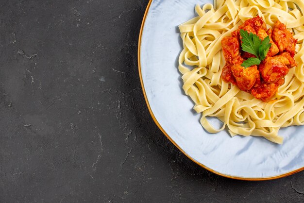 Top Nahaufnahme appetitliche Pasta appetitliche Pasta mit Fleisch und Soße auf dem dunklen Tisch