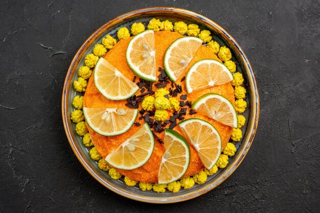 Top Nahaufnahme appetitlicher Kuchen appetitlicher Kuchen mit Zitrusfrüchten auf dem grauen Teller auf dem dunklen Tisch