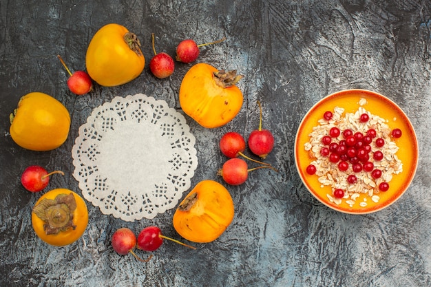 Top Nahaufnahme Beeren die appetitlichen Kirsch Persimonen um Spitze Deckchen Schüssel mit roten Johannisbeeren