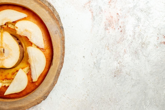 Top Nahaufnahme Birnenkuchen Birnenkuchen auf dem Holzbrett auf der linken Seite des Leuchttisches