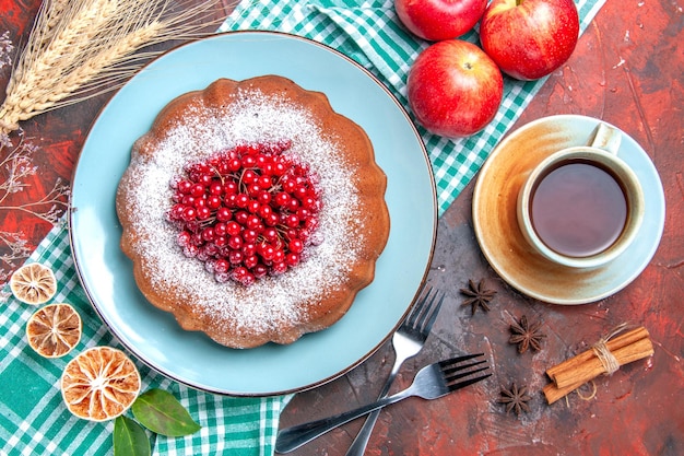 Top Nahaufnahme einen Kuchen eine Tasse Tee Zimt Sternanis Gabeln einen Kuchen Äpfel auf der Tischdecke