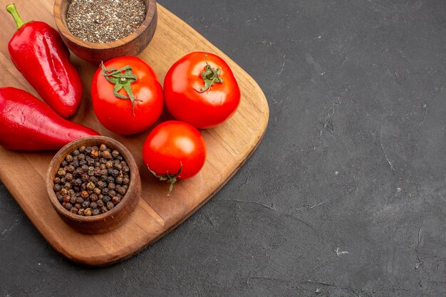 Top Nahaufnahme frische rote Tomaten mit Gewürzen auf dunklem Raum