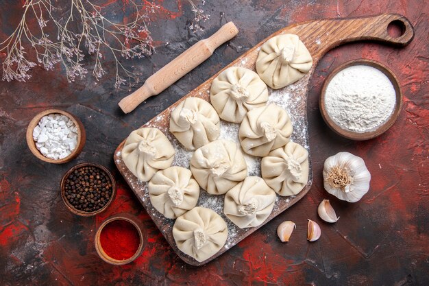 Top-Nahaufnahme Khinkali das appetitliche Khinkali auf dem Brett Knoblauch Schüssel Mehlgewürze