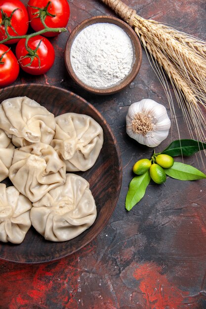 Top-Nahaufnahme Khinkali leckere Khinkali Zitrusfrüchte Mehl Weizen Ohren Ohren Tomaten