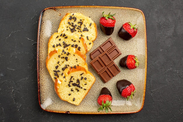 Top Nahaufnahme Kuchenstücke appetitliche Kuchenstücke mit Schokolade und Erdbeeren auf dunklem Tisch dark