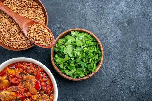 Top Nahaufnahme leckere Gemüsesuppe mit rohem Buchweizen auf Grauraum