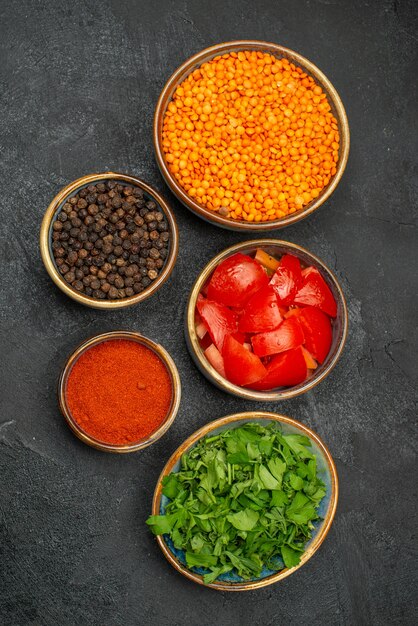 Top-Nahaufnahme Linsenschalen mit Linsen-Tomaten würzen Kräuter mit schwarzem Pfeffer