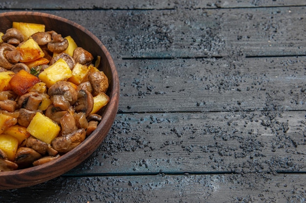 Top Nahaufnahme Schüssel mit Essen Holzschüssel mit Kartoffeln und Pilzen auf der linken Seite des Tisches