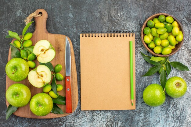 Top-Nahaufnahmefrüchte Früchte das appetitliche Äpfel Messer auf dem Brett Zitrusfrüchte Notizbuch Bleistift