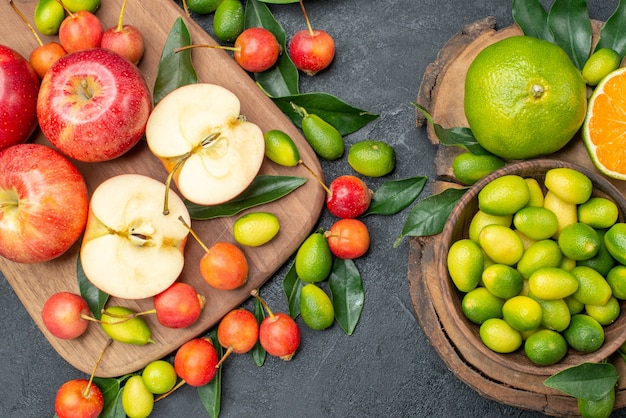 Top-Nahaufnahmefrüchte Früchte rote Äpfel auf dem Brett Kirschen und Zitrusfrüchte in Schüssel