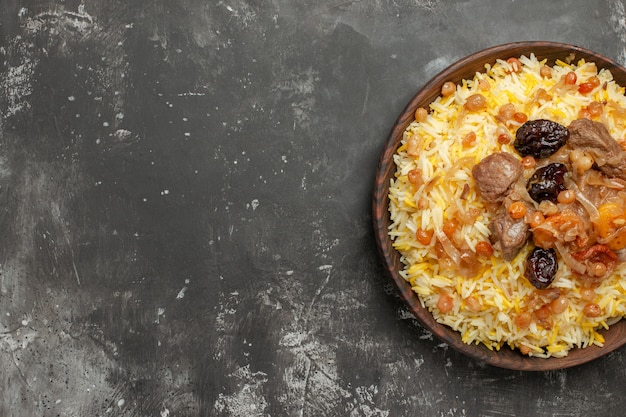 Top-Nahaufnahmepilaf ein appetitlicher Pilaw mit fleischgetrockneten Früchten in der braunen Schüssel