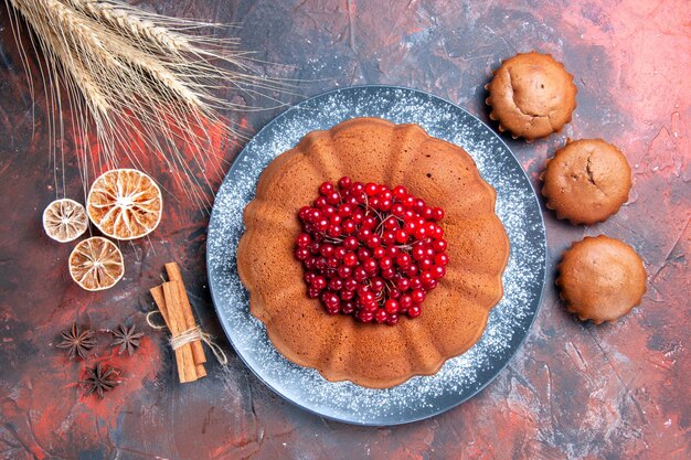 Top View Kuchen und Cupcakes ein appetitlicher Kuchen Cupcakes Weizenähren Zimtstangen Zitrone