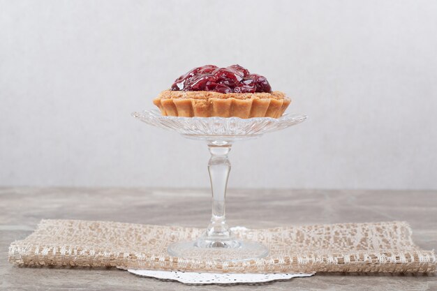 Tortenkuchen mit Früchten auf Glasplatte.