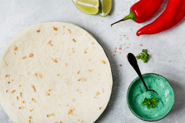 Tortilla in der Nähe von Bio-Sauce und Chili
