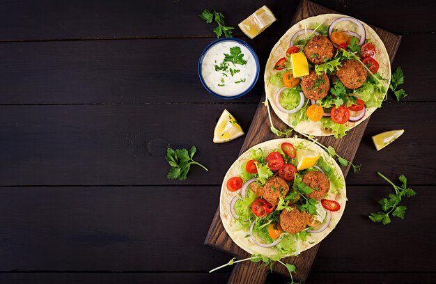 Tortilla Wrap mit Falafel und frischem Salat. Vegane Tacos. Vegetarisches gesundes Essen. Draufsicht