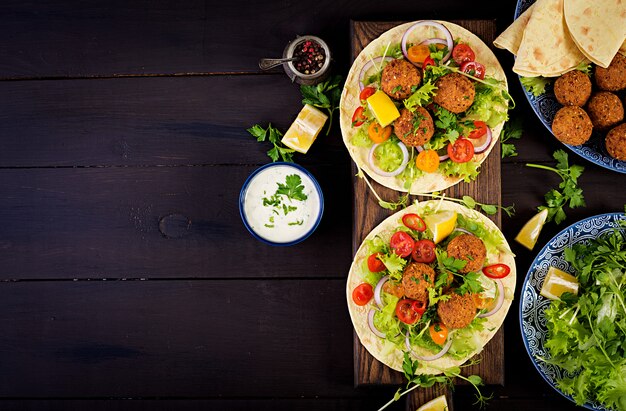 Tortilla Wrap mit Falafel und frischem Salat. Vegane Tacos. Vegetarisches gesundes Essen. Draufsicht