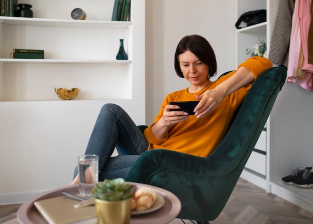 Kostenloses Foto totale aufnahme einer frau, die mit ihrem telefon spielt