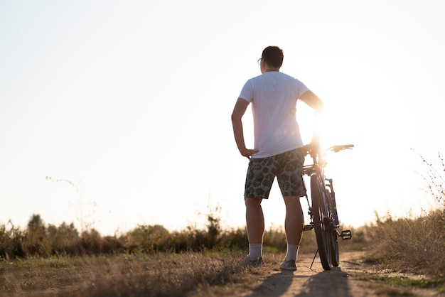 Kostenloses Foto totale eines mannes mit einem fahrrad, das weg schaut
