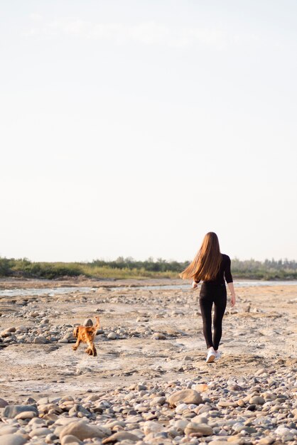 Totale Frau mit ihrem Hund spazieren