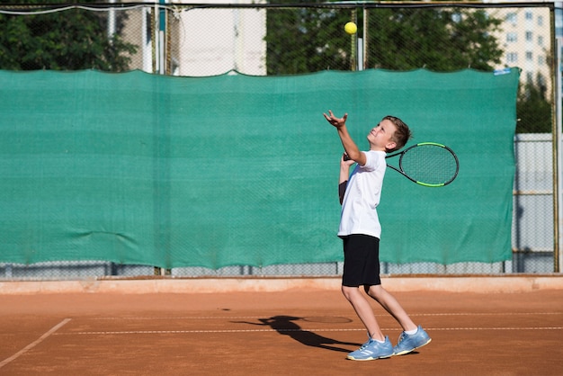 Totale Kind, das auf Tennisfeld dient