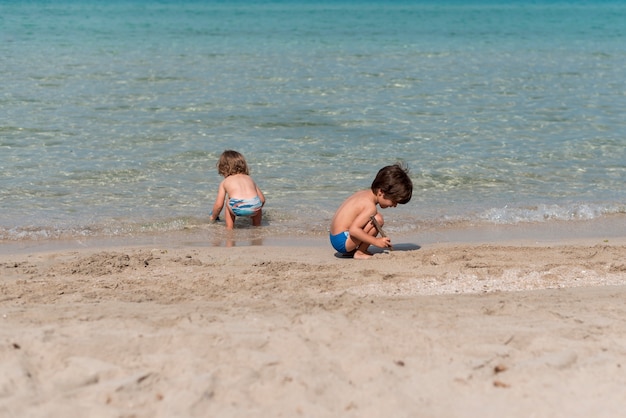 Totale von Kindern, die am Strand spielen