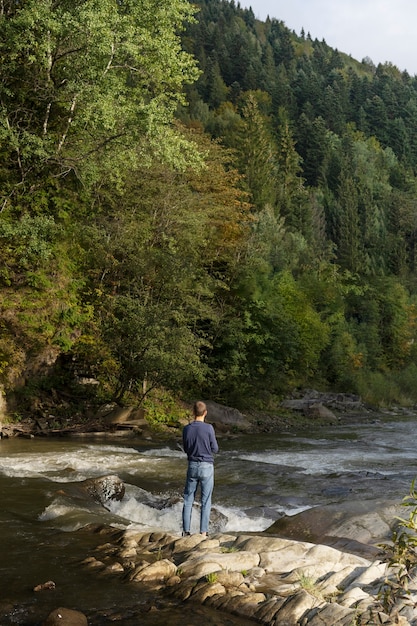 Kostenloses Foto totaler mann, der den fluss betrachtet