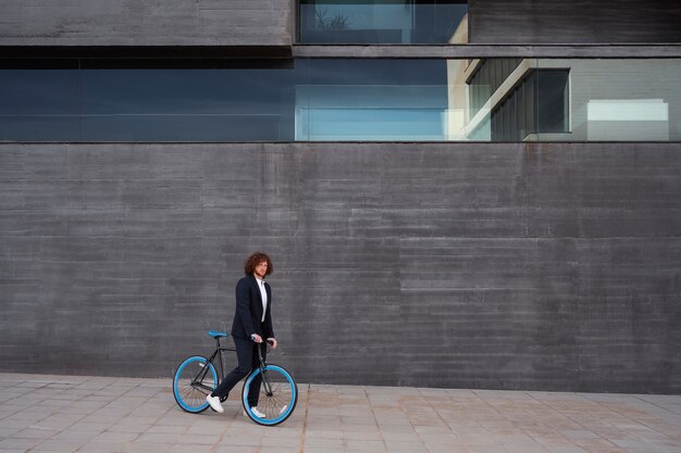 Totaler Mann mit Fahrrad, der zur Arbeit geht