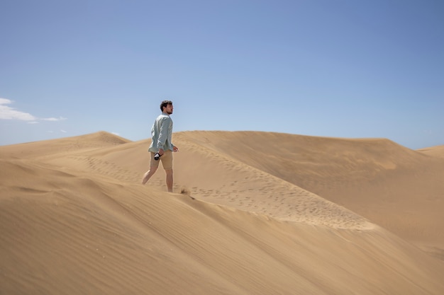 Totaler Mann mit Fotokamera in der Wüste