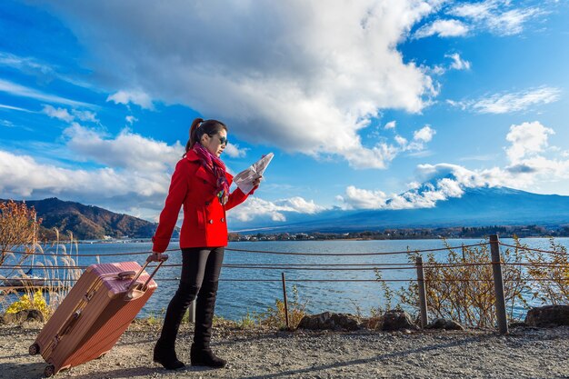 Tourist mit Gepäck und Karte am Fuji-Berg, Kawaguchiko in Japan.