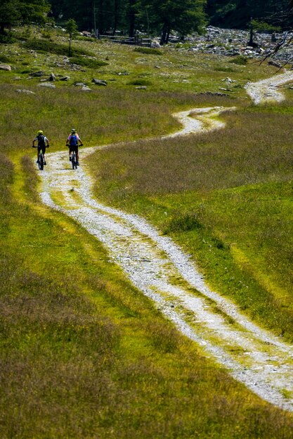 Touristen, die auf einer Wiese mit einer wunderschönen Landschaft Fahrrad fahren