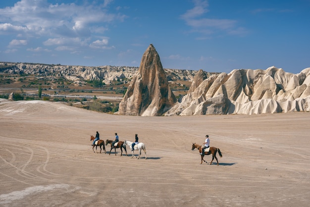 Kostenloses Foto touristen genießen reitpferde in kappadokien, türkei