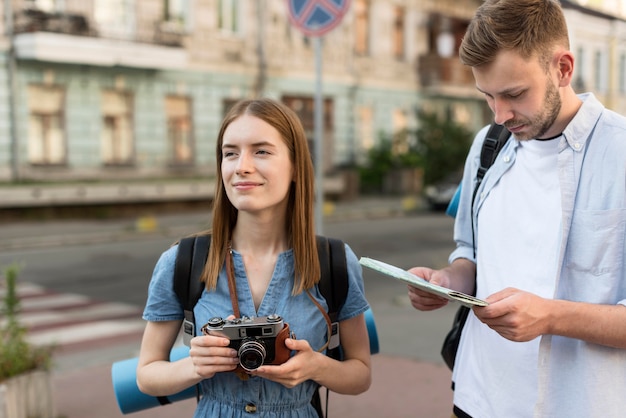 Touristenpaar, das Kamera und Karte hält