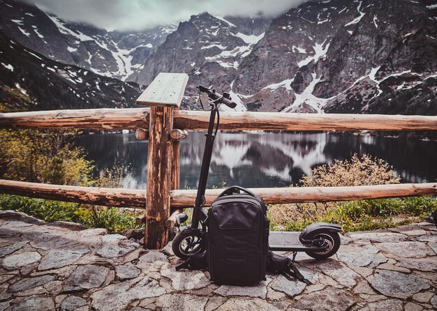 Touristischer Aussichtspunkt mit herrlichem Blick auf Berge und See mit Spiegelung. Trere sind Roller an der Front.