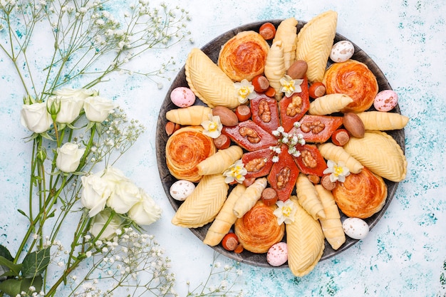 Traditionelle aserbaidschanische feiertags-novruz-kekse baklavas und shakarburas auf schwarzem tablettteller auf licht