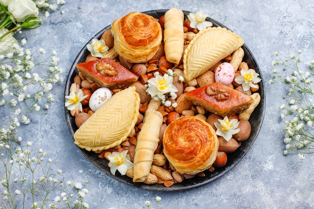 Traditionelle aserbaidschanische Feiertags-Novruz-Kekse Baklavas und Shakarburas auf schwarzer Tablettplatte auf dem grauen Beton