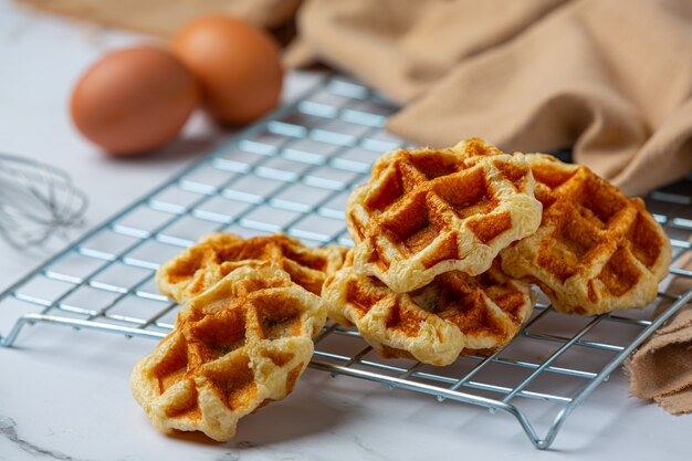 Traditionelle belgische Waffeln, Blutorangen und Blaubeeren Dressing und Tasse Kaffee für süßes Frühstück, Zusammensetzung auf hellem Hintergrund.