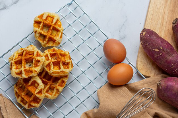 Traditionelle belgische Waffeln, Blutorangen und Blaubeeren Dressing und Tasse Kaffee für süßes Frühstück, Zusammensetzung auf hellem Hintergrund.