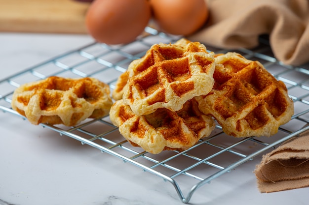 Traditionelle belgische Waffeln, Blutorangen und Blaubeeren Dressing und Tasse Kaffee für süßes Frühstück, Zusammensetzung auf hellem Hintergrund.