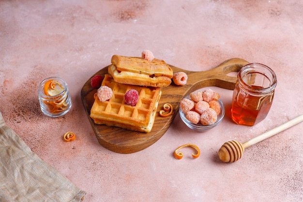 Traditionelle belgische Waffeln mit Honig und gefrorenen Beeren.