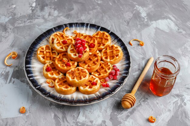 Traditionelle belgische Waffeln mit Honig und gefrorenen Beeren.